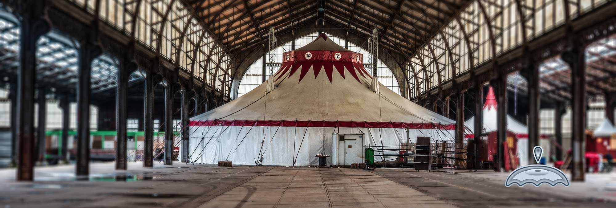 chapiteau de cirque à l'interieur d'un hangard qui semble désaffecté