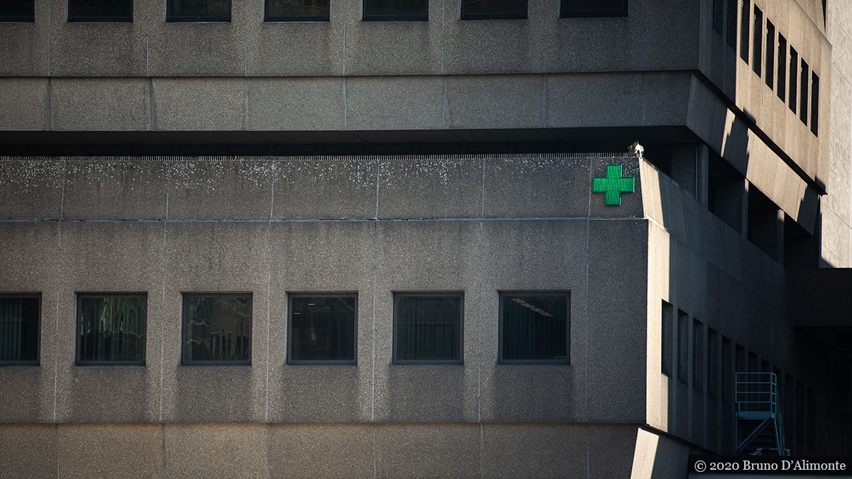 Photographie d'illustration sur le covid représentant l'icône d'une pharmacie au centre d'une architecture austère, quasi inhumaine trouvée à Bruxelles, gare du Nord. © 2020 Bruno D'Alimonte