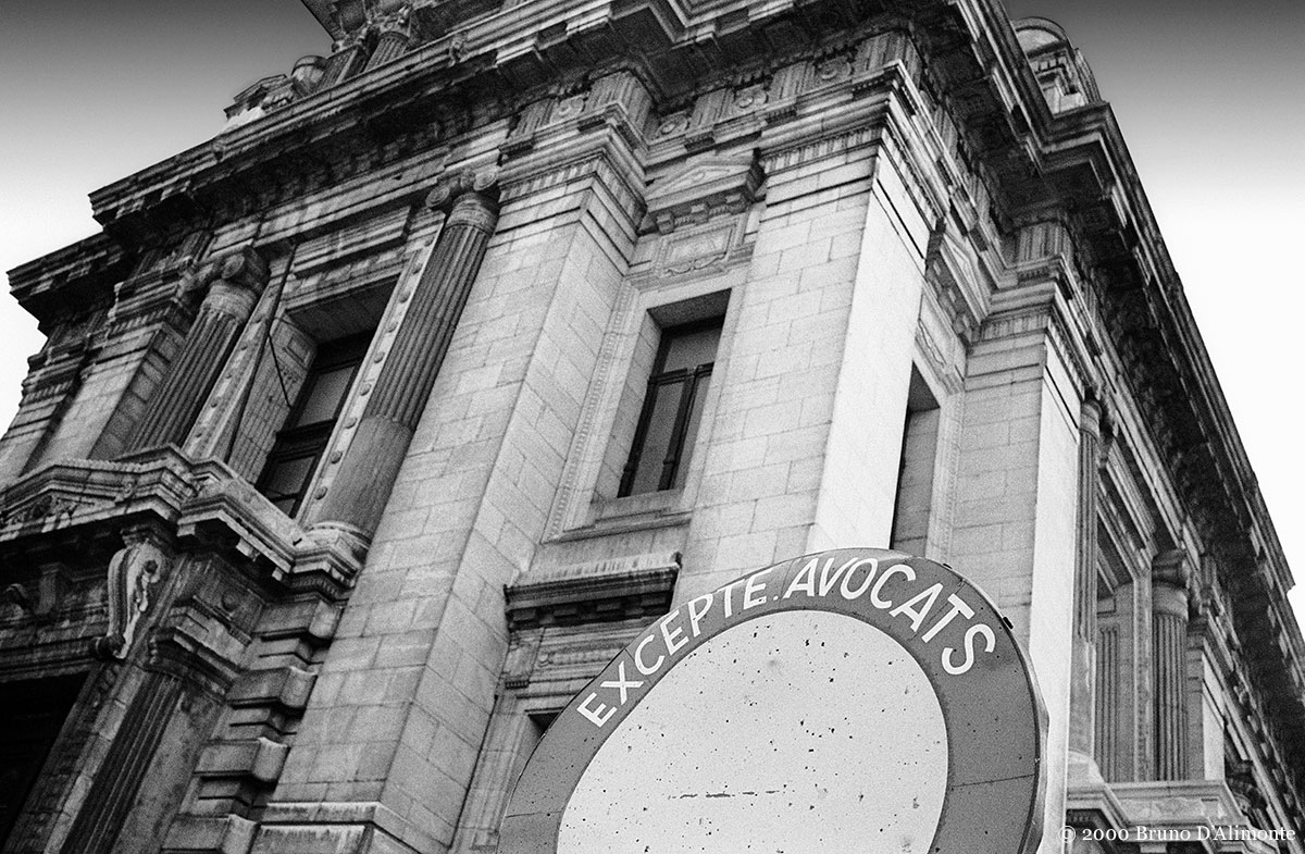 Photographie en noir et blanc du palais de justice de Bruxelles avec comme avant-plan un panneau d'interdiction de circuler à l'exception des avocats.© 2000 Bruno D'Alimonte 