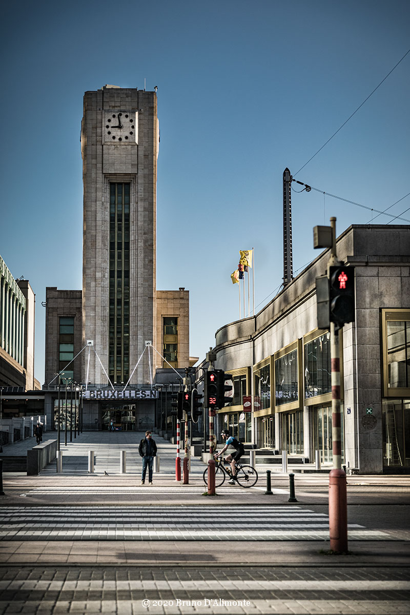 photographie de la Tour de l'horloge de la gare du nord à Bruxelles avec un passant et un cycliste. © 2020 Bruno D'Alimonte