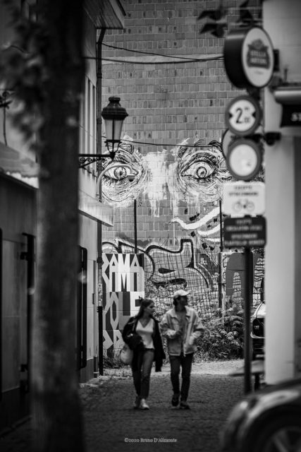 Rue du Pays de Liège à Bruxelles, un couple se promène alors que deux yeux les surveillent © 2020 Bruno D'Alimonte