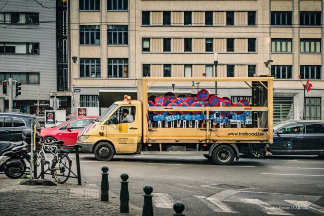 Véhicule de voirie transportant des panneaux d'interdiction de stationner en ville au milieu du trafic. Quai au charbonnage et boulevard de nieuport. Image issue de la collection Brussels'Eyes. © 2017 Bruno D'Alimonte 