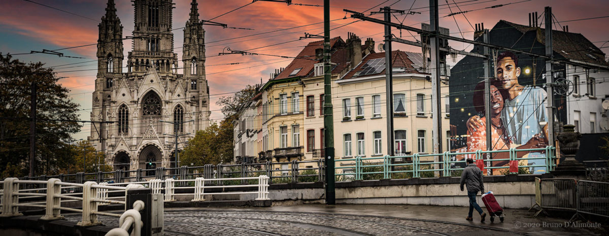 photographie panoramique représentant l'église Notre Dame de Laeken avec un passant muni d'un caddie et une fresque de street art de l'artiste NEAN dans un contexte pictural. Photo issue de la collection Brussels Eyes de Bruno D'Alimonte 