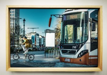 Cycliste et Bus de la Stib cohabitent sur une image intitulée Héros en rappel à la destination du bus