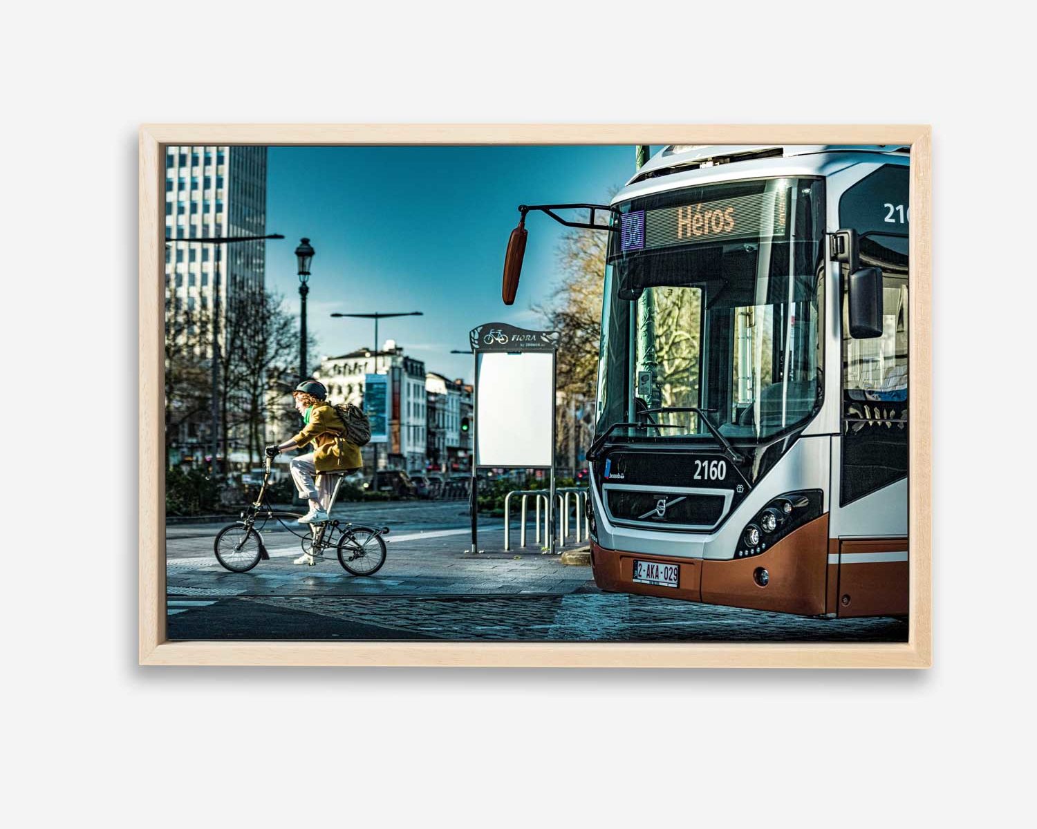 Cycliste et Bus de la Stib cohabitent sur une image intitulée Héros en rappel à la destination du bus